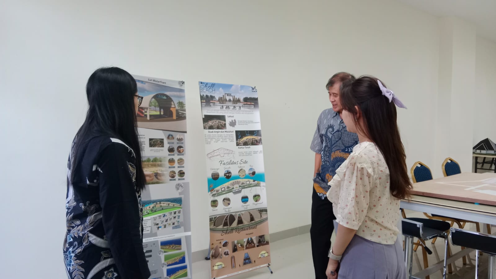 A group of people looking at a poster
Description automatically generated
