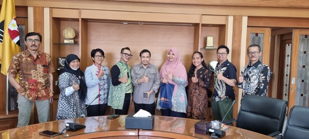 A group of people standing in front of a table

Description automatically generated