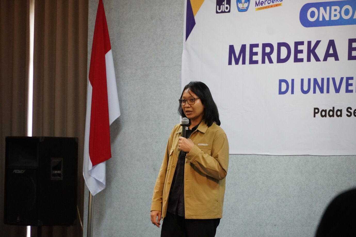 A person standing in front of a microphone
Description automatically generated