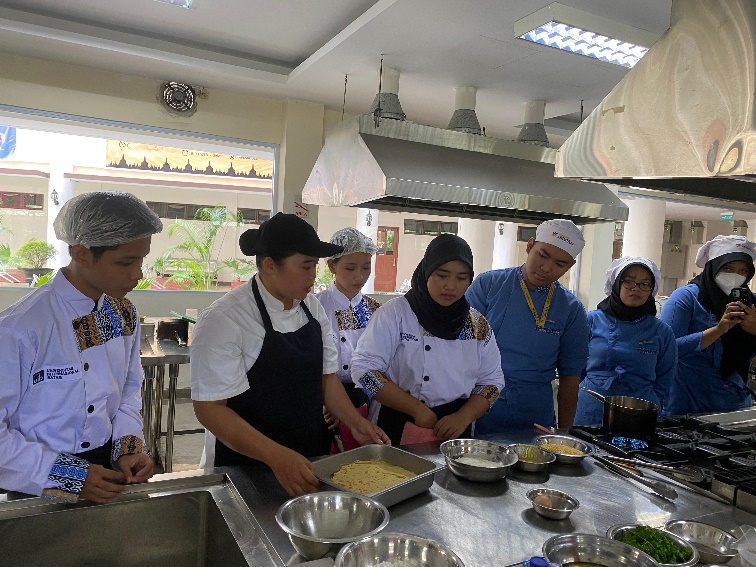 A group of people in a kitchen

Description automatically generated