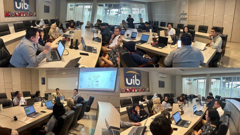 A group of people in a room with laptops Description automatically generated