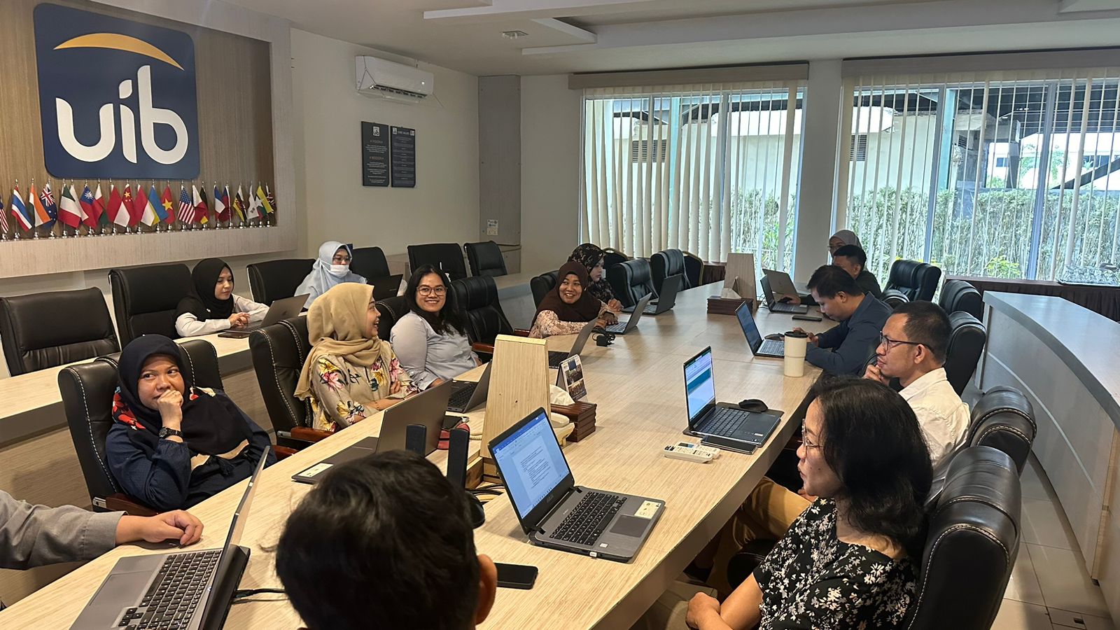 A group of people sitting at a table with laptops

Description automatically generated