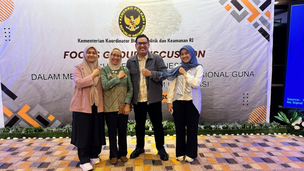 A group of people standing in front of a banner Description automatically generated
