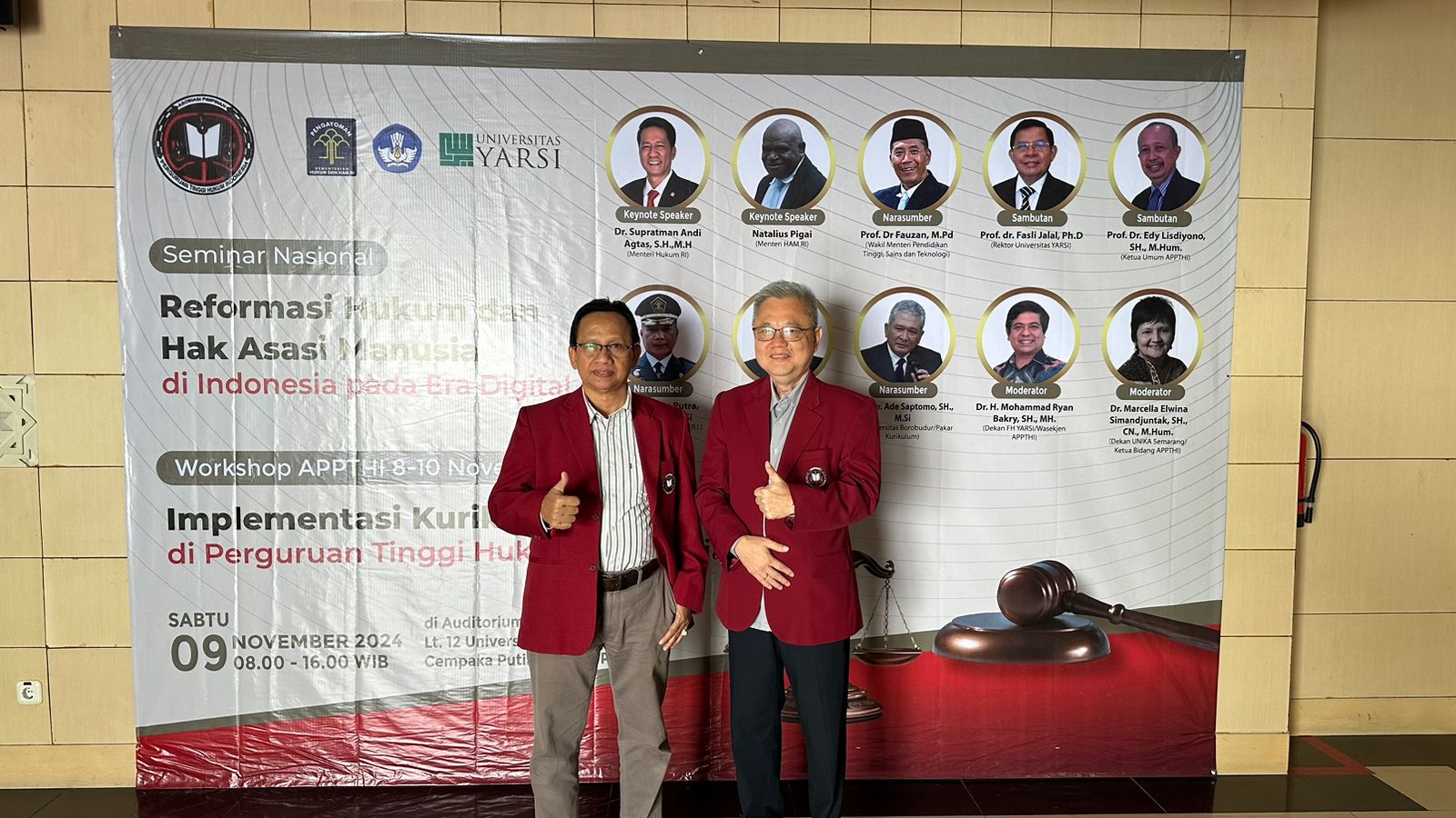 Two men standing in front of a banner Description automatically generated