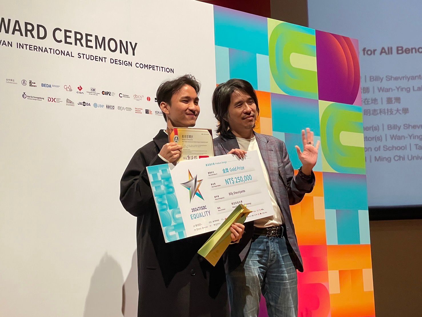 A couple of men holding certificates

Description automatically generated