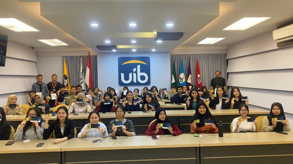 A group of people sitting at tables in a room with flags Description automatically generated