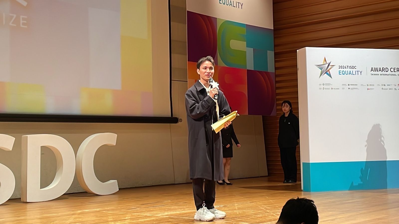 A person holding a microphone

Description automatically generated