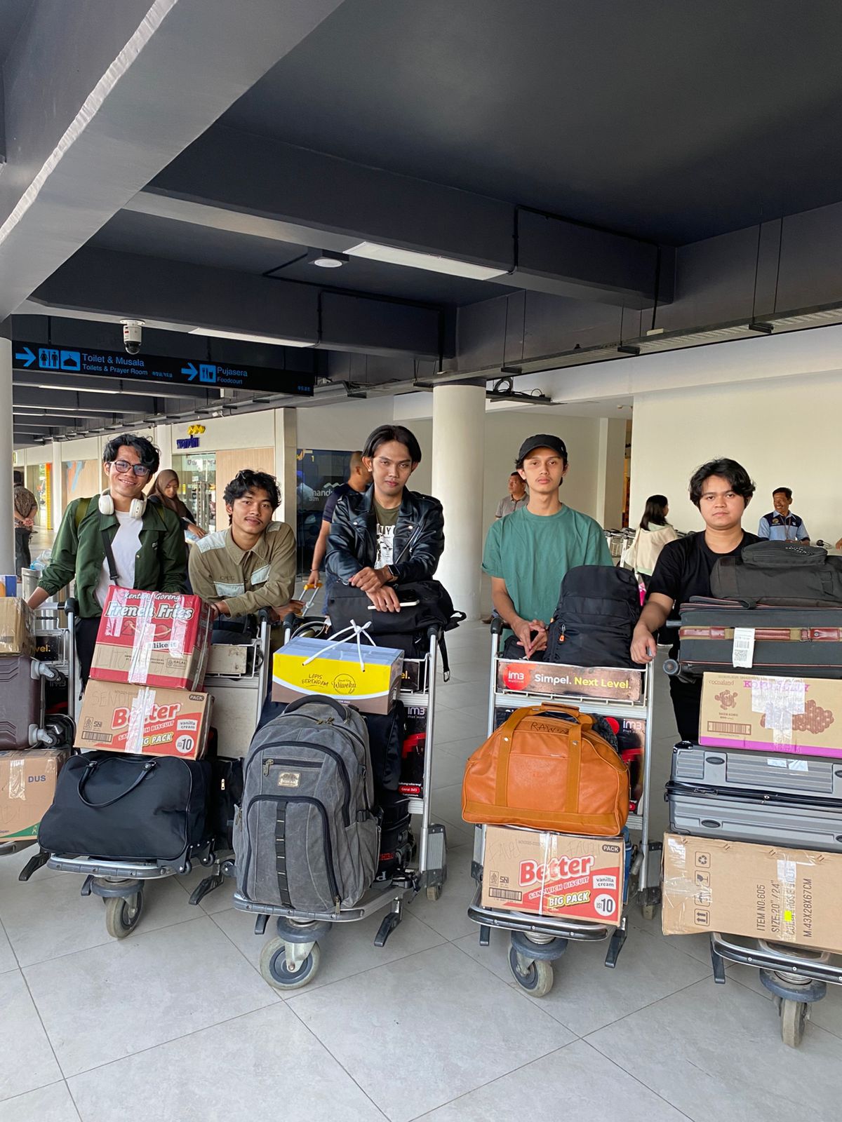 A group of people standing with luggage

Description automatically generated