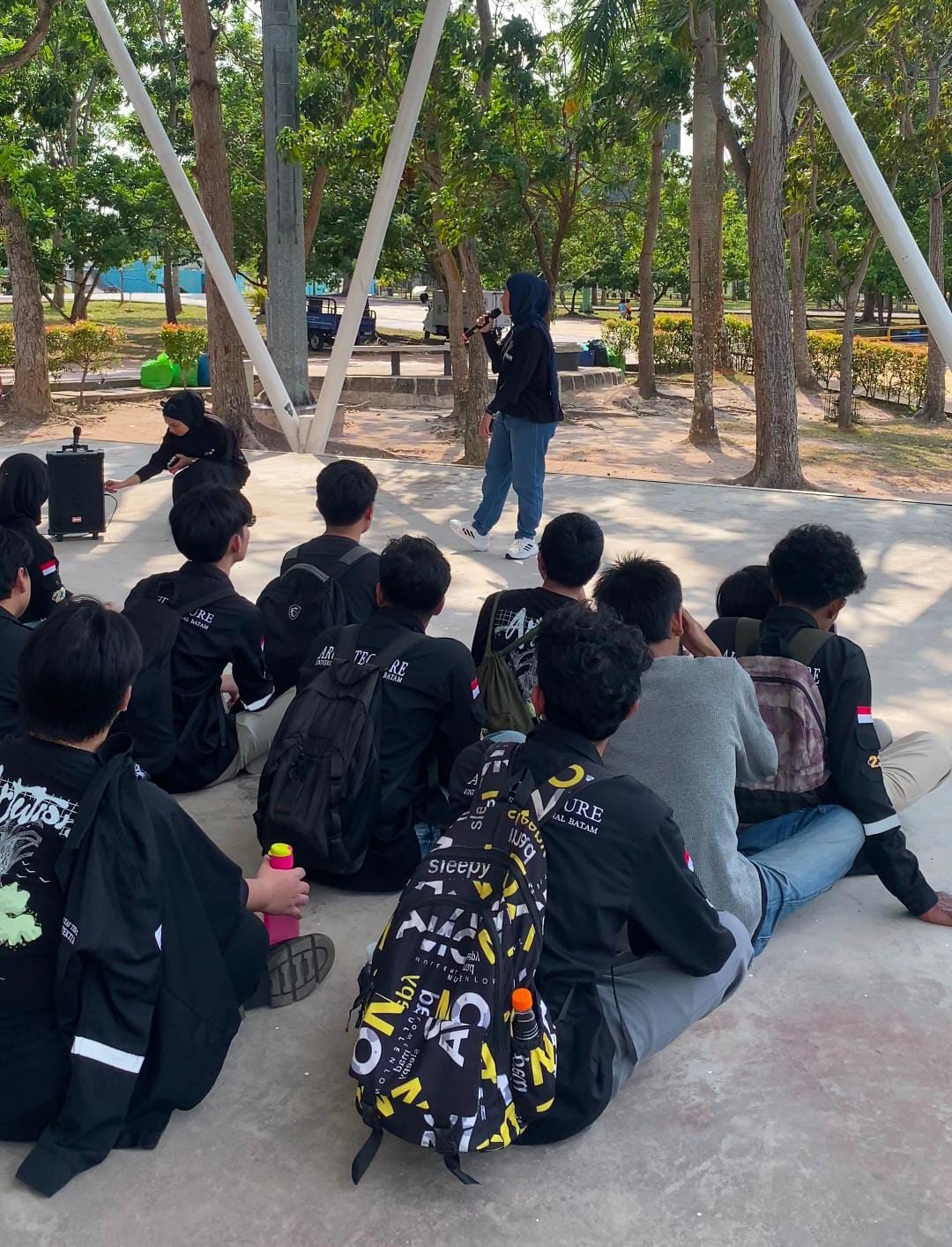 A group of people sitting on the ground AI-generated content may be incorrect.