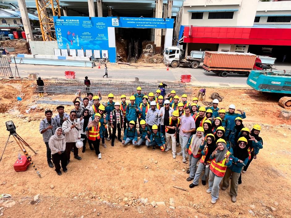 A group of people in hard hats and vests standing in a circle

Description automatically generated