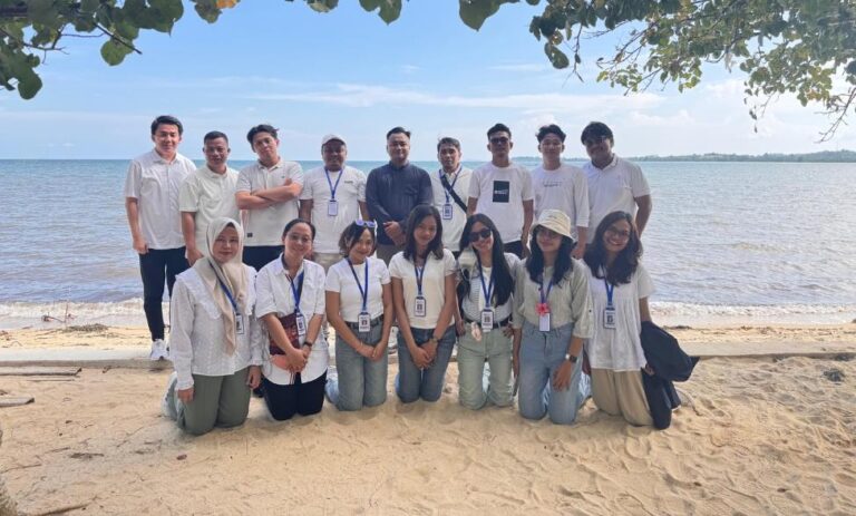 A group of people posing for a photo on a beach Description automatically generated