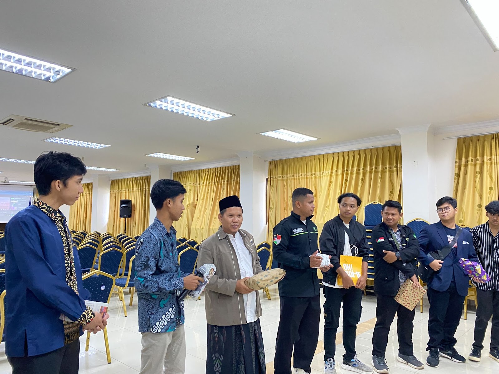 A group of people standing in a room

AI-generated content may be incorrect.