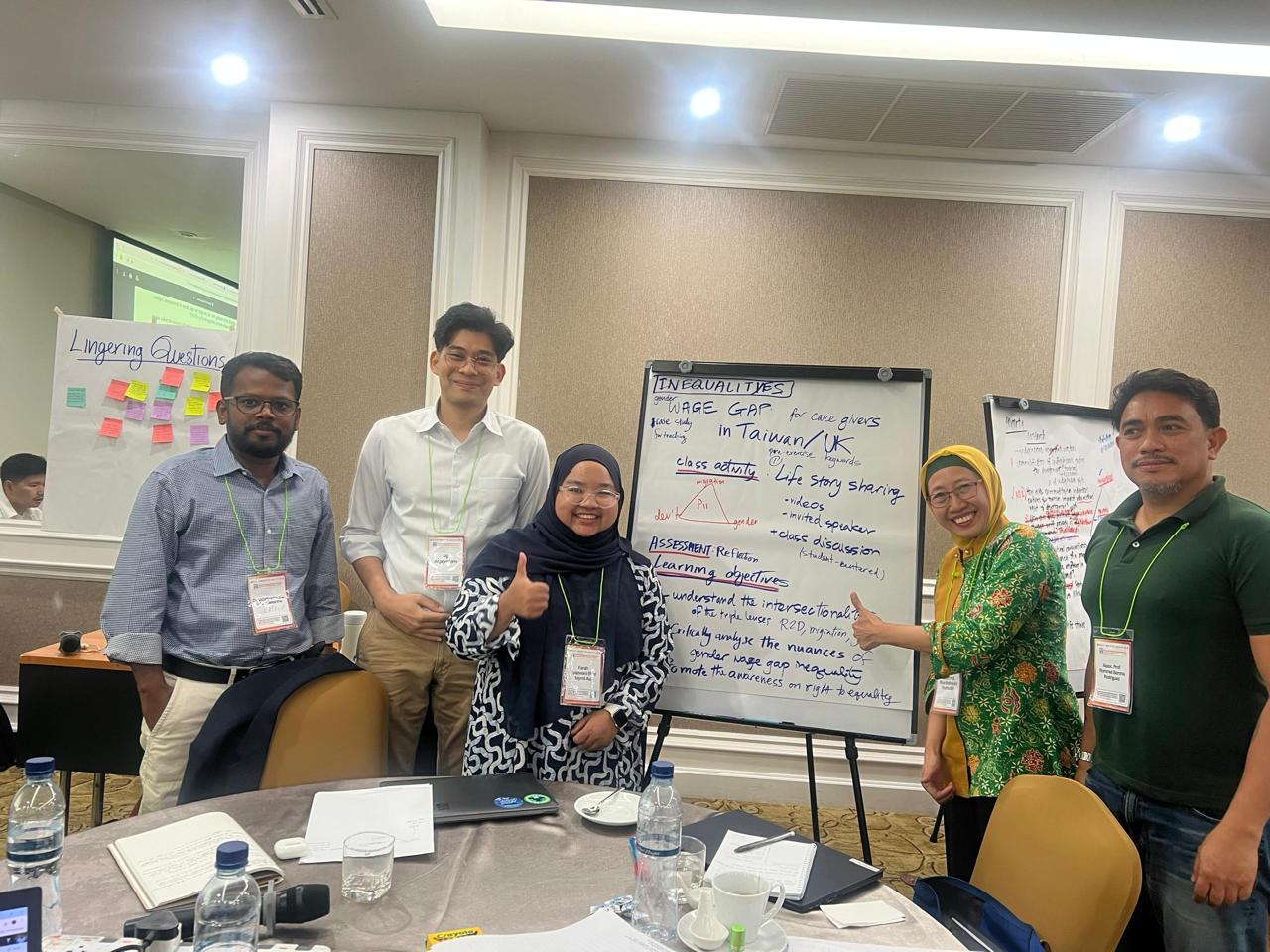 A group of people standing in front of a whiteboard

Description automatically generated