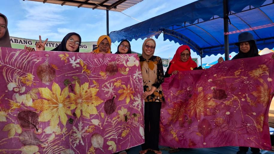 A group of women holding up large pink posters

Description automatically generated