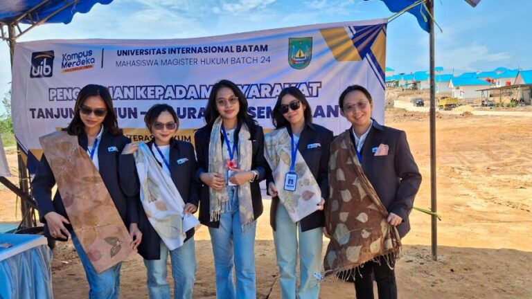 A group of women standing in front of a banner Description automatically generated