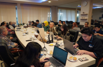 A group of people sitting at a table with laptops AI-generated content may be incorrect.
