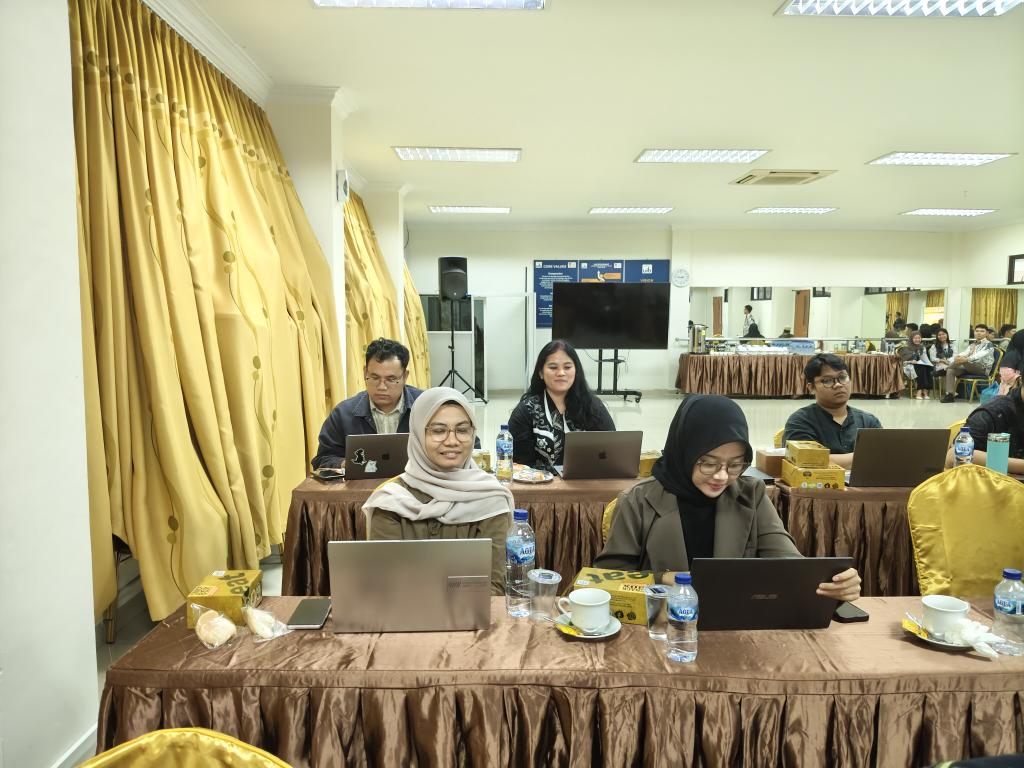 A group of people sitting at tables with laptops AI-generated content may be incorrect.