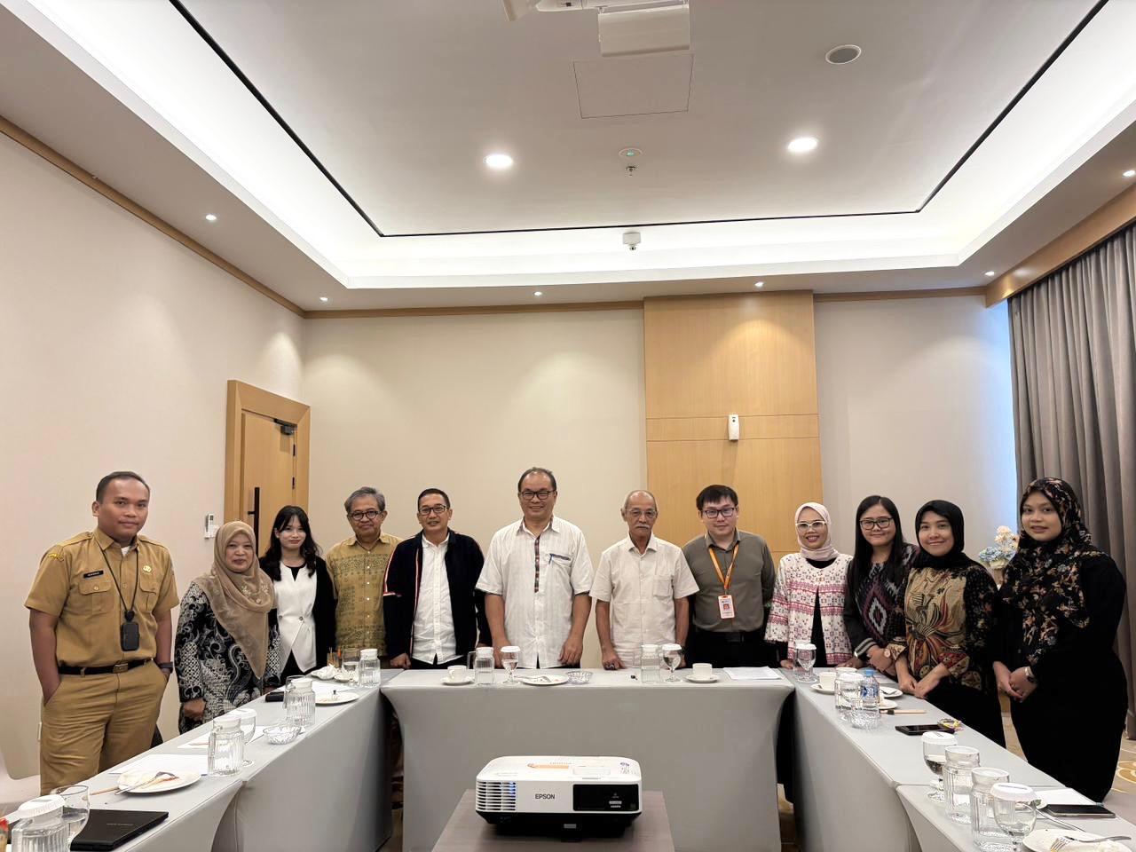 A group of people standing around a table Description automatically generated