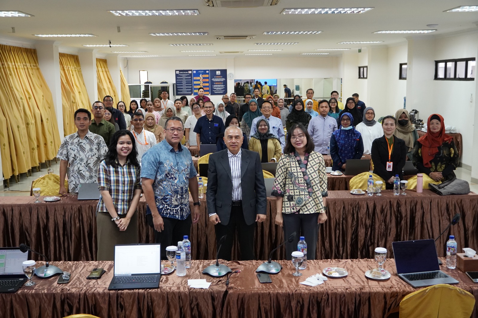 A group of people standing in a room
AI-generated content may be incorrect.