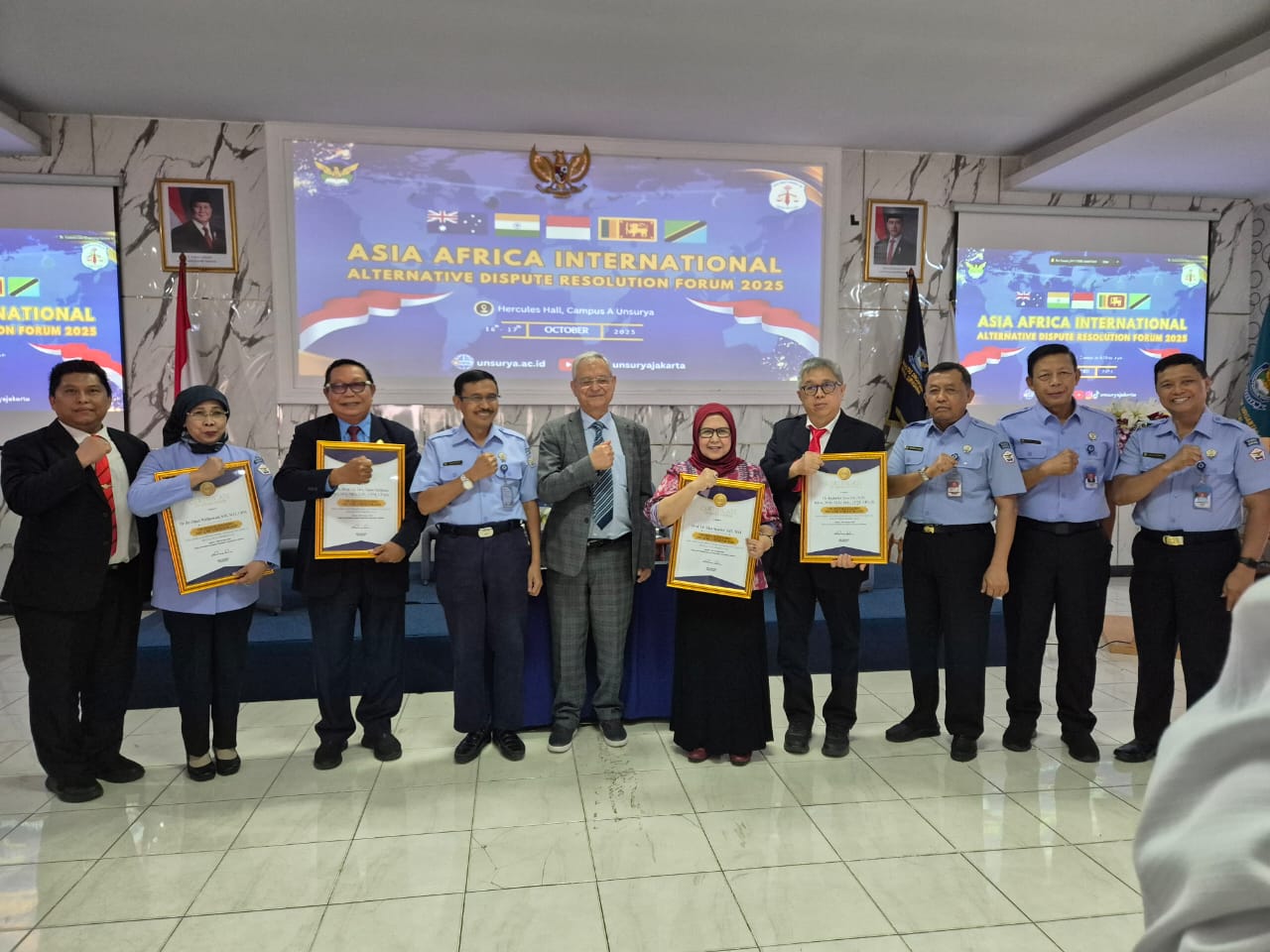 A group of people holding certificates Description automatically generated