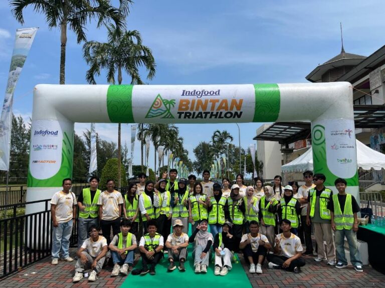 A group of people standing under a white and green arch AI-generated content may be incorrect.