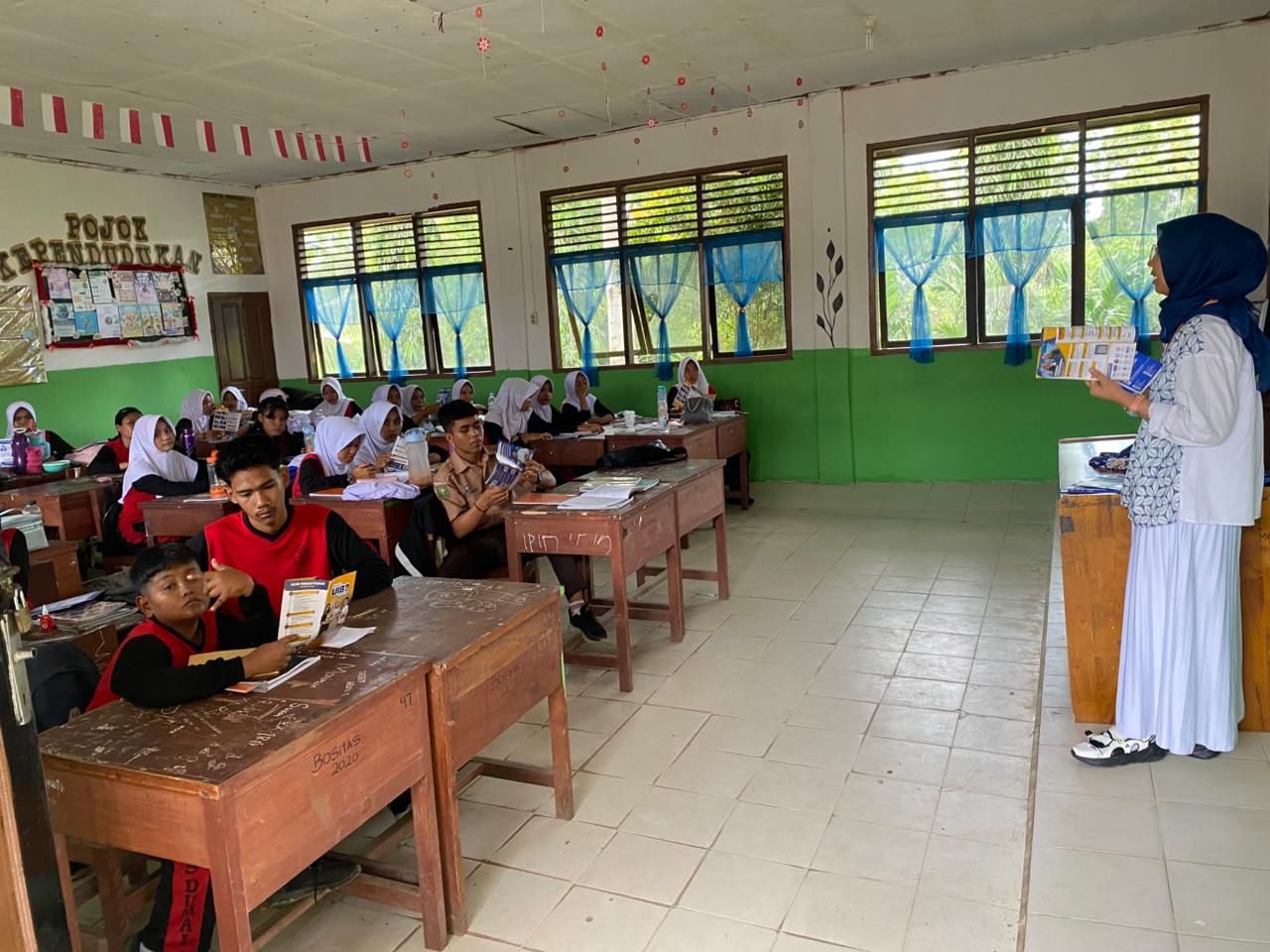A person standing in front of a classroom Description automatically generated