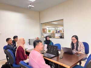 A group of people sitting at a table with laptops AI-generated content may be incorrect.