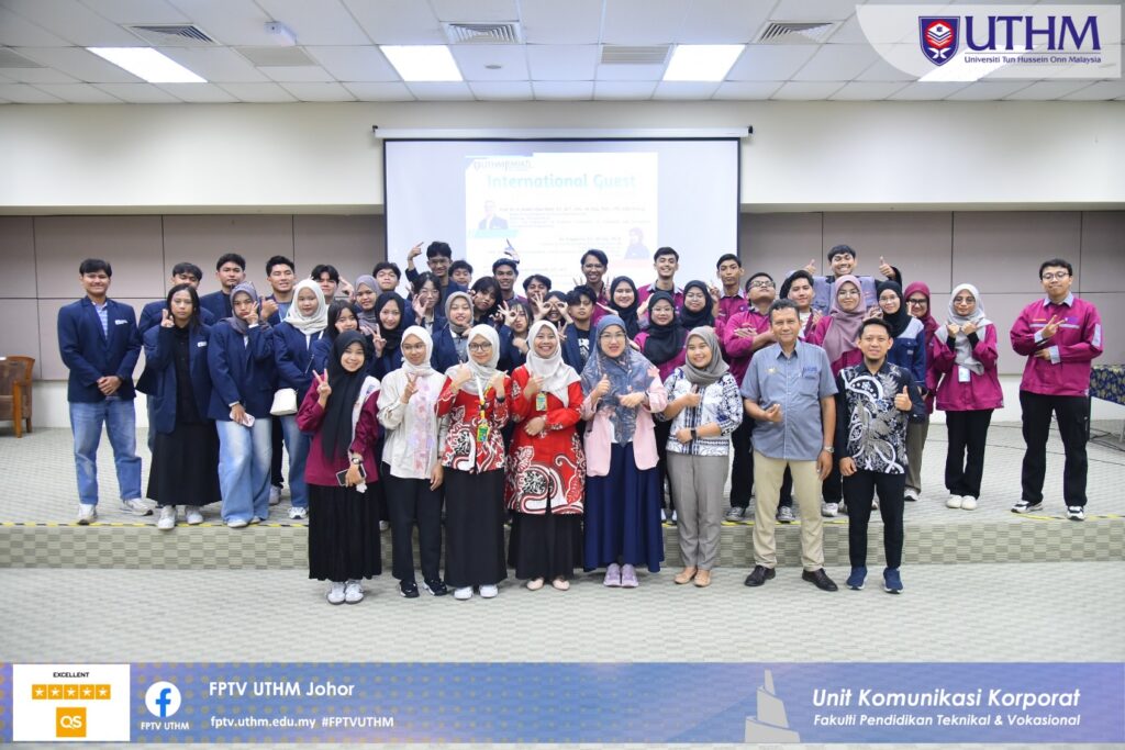 A group of people standing in front of a projector screen Description automatically generated