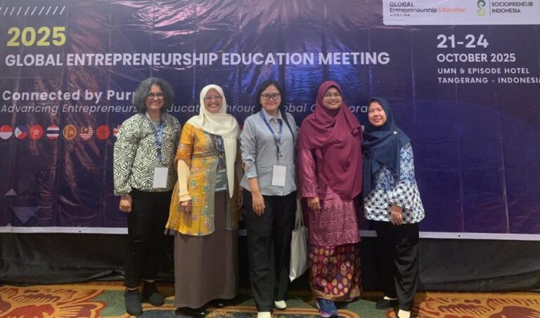 A group of women standing in front of a banner Description automatically generated