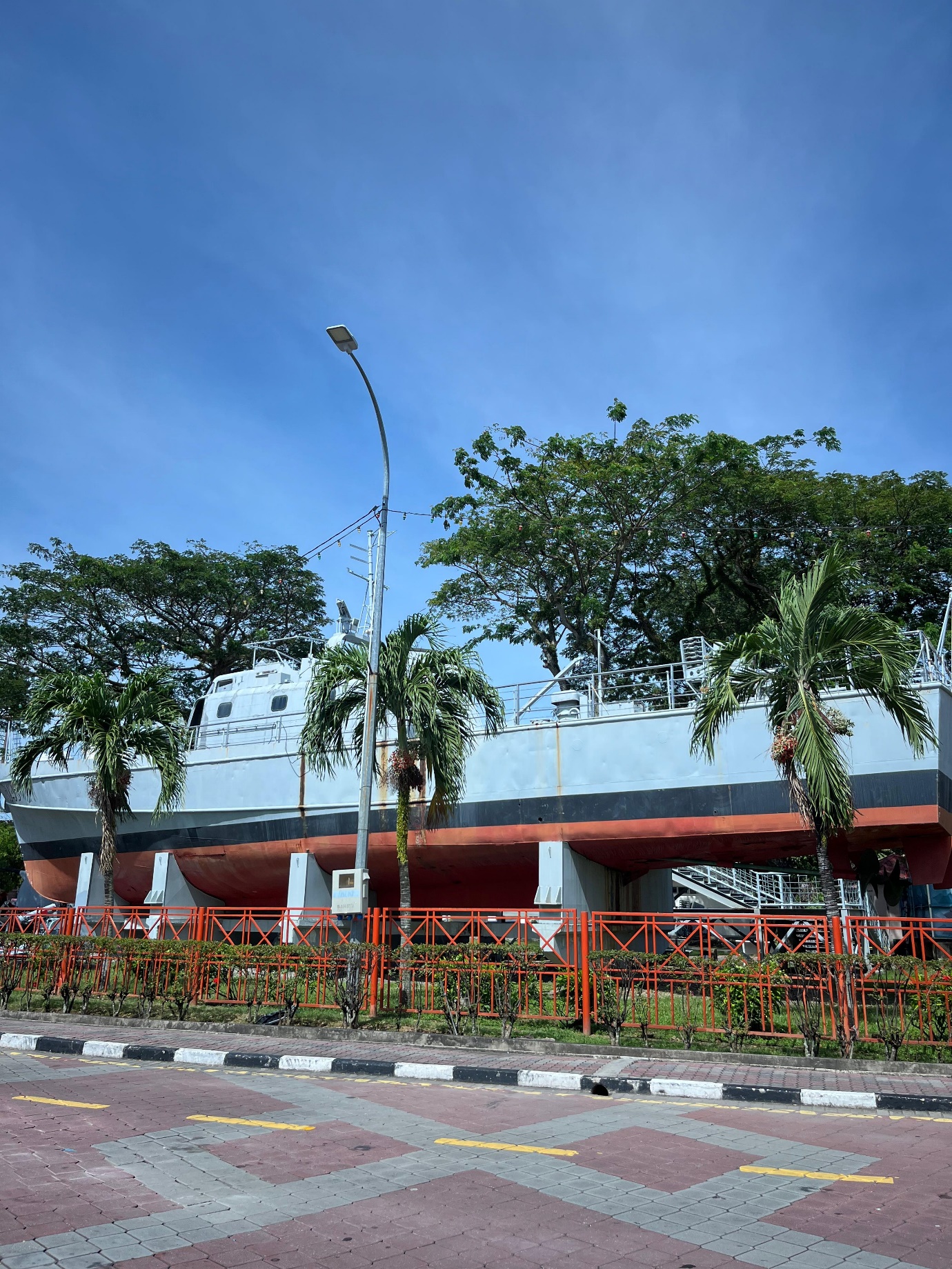 A large ship in front of a parking lot
Description automatically generated