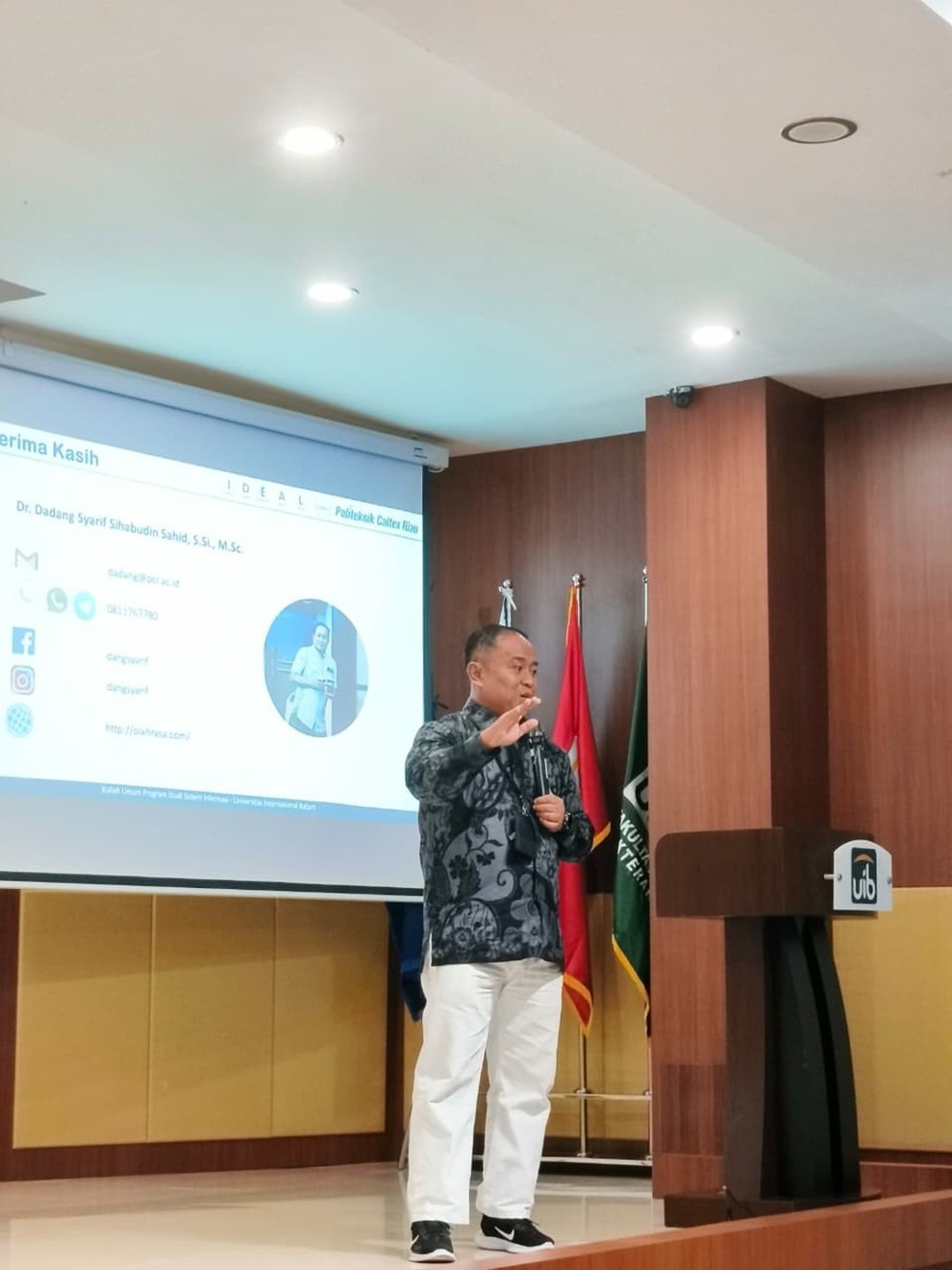 A person standing in front of a screen

AI-generated content may be incorrect.