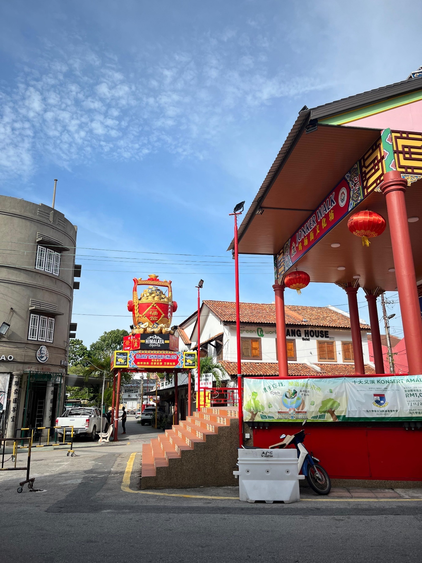 A street with buildings and a sign
Description automatically generated