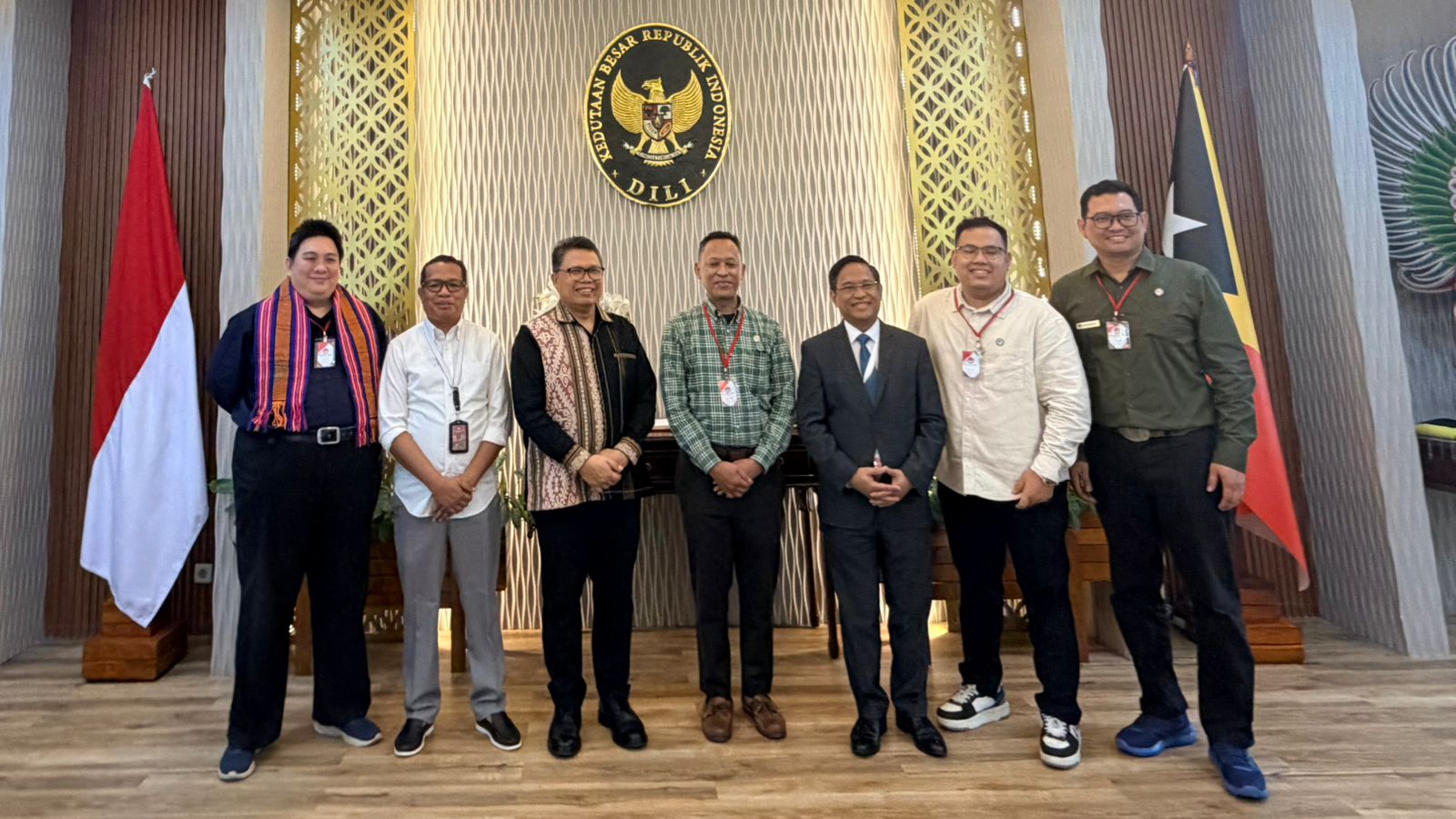 A group of men standing in front of a wall Description automatically generated