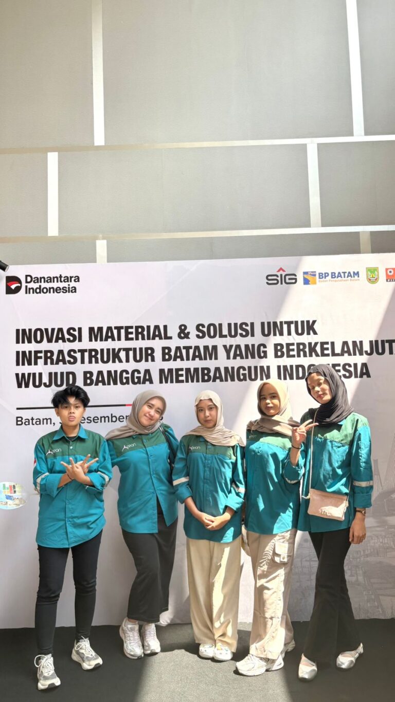 A group of people standing in front of a sign Description automatically generated