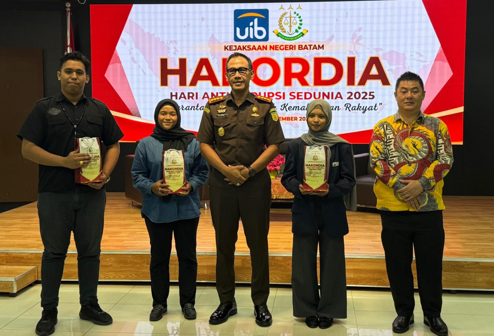 A group of people standing in front of a stage Description automatically generated