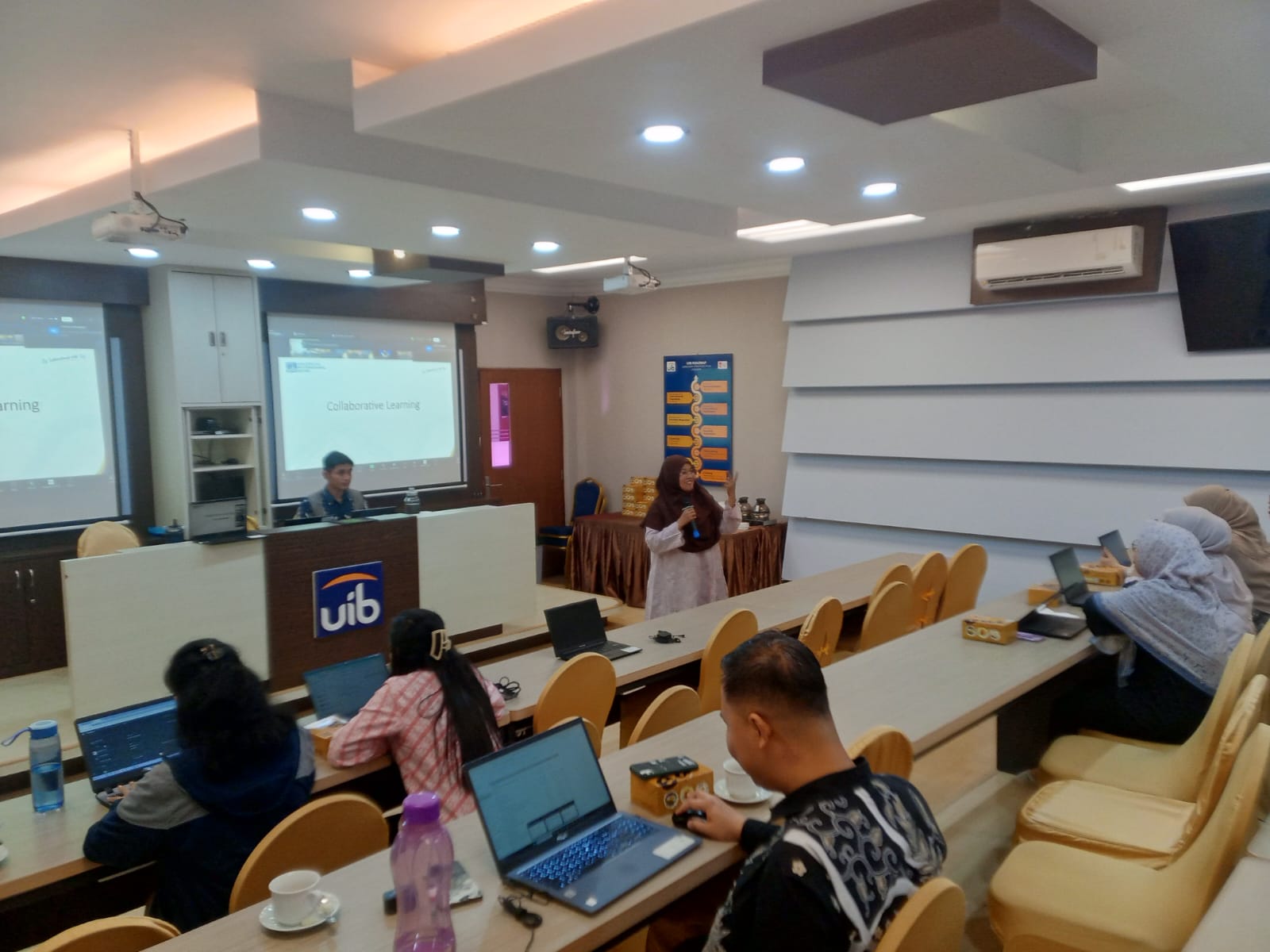 A group of people in a room with laptops

Description automatically generated