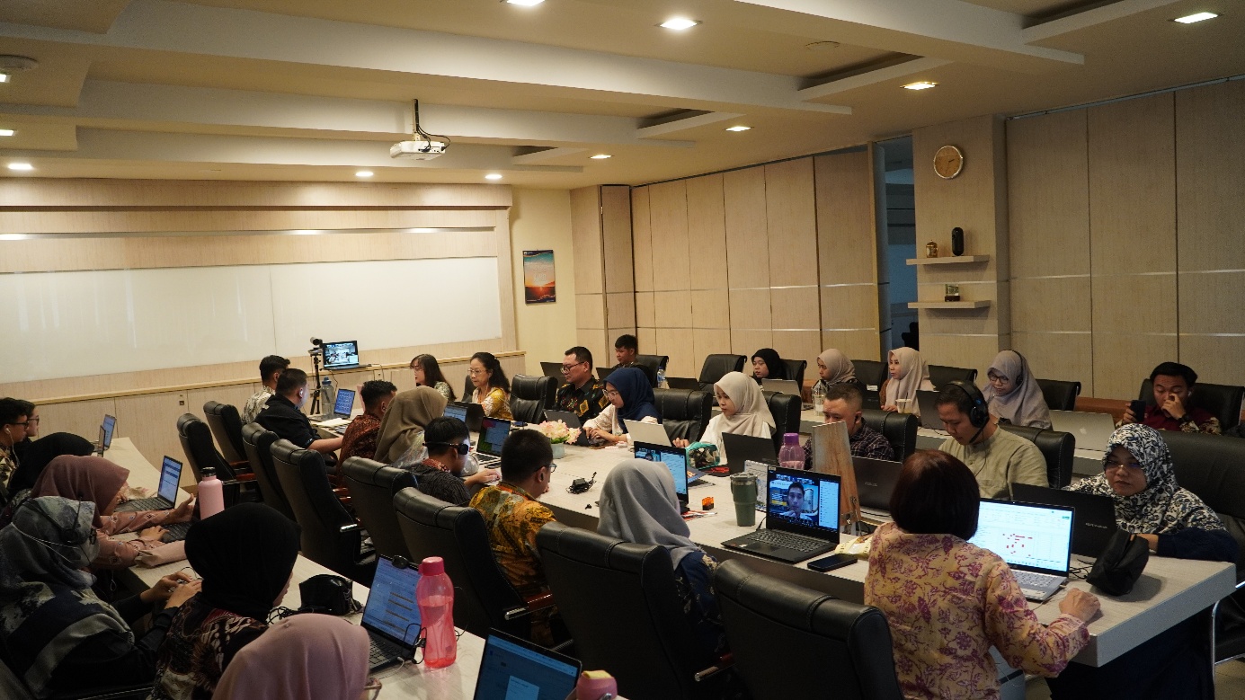 A group of people sitting around a table with laptops

Description automatically generated