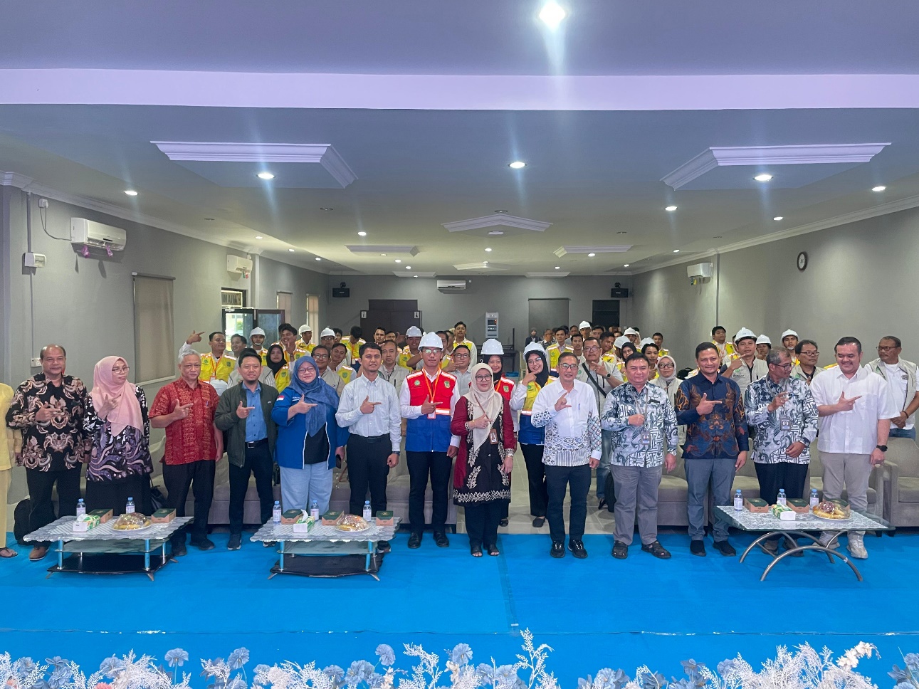 A group of people standing in a room Description automatically generated