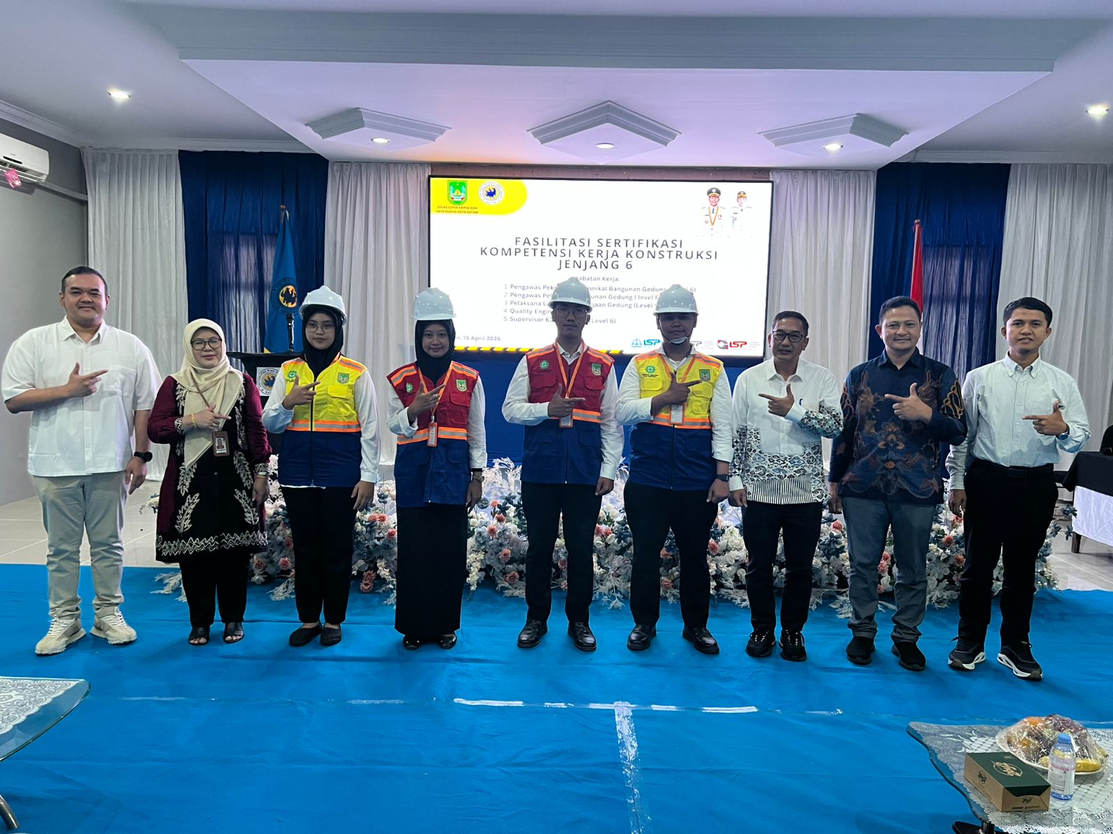 A group of people standing in a room Description automatically generated