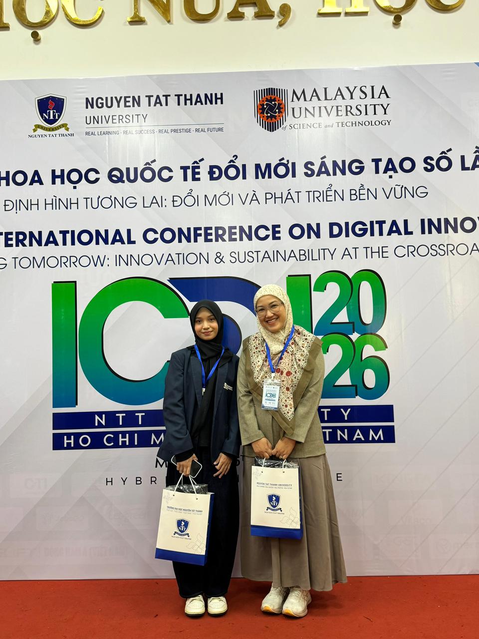 A couple of women standing in front of a banner
Description automatically generated