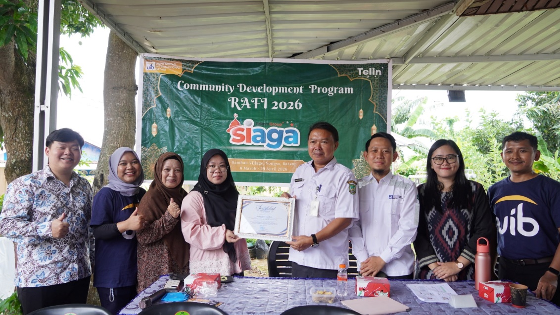 A group of people standing in front of a banner Description automatically generated